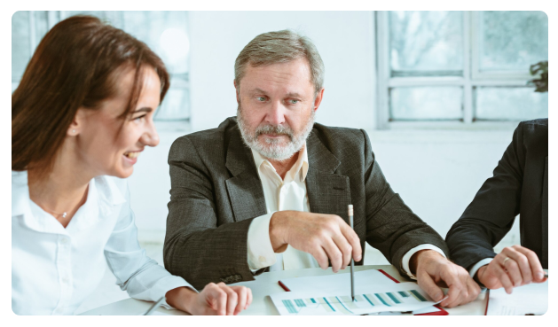 Two colleagues reviewing financial charts across a meeting table